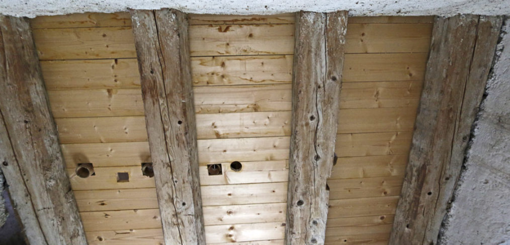 Holzdecke mit alten Holzbalken und Rissen